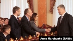 Ukrainian President Petro Poroshenko (right) shakes hands with new judges from Ukraine's High Anti-Corruption Court during an oath-taking ceremony on April 11. 