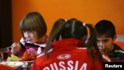 Children eat at an orphanage in the southern Russian city of Rostov-na-Donu. No "puppies" who will grow up to be "good attack dogs" here...