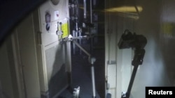 A remote-controlled robot called "Packbot" opens a door at the crippled Fukushima Daiichi Nuclear Power Plant's No.3 reactor building on April 17.