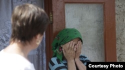 A woman weeps at a center for reabilitating victims of domestic violence in Moldova. (file photo)