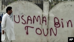 A man walks past graffiti reading "Usama Bin Town" in Abbottabad on May 6.