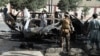 Afghan security forces inspect the wreckage of a passenger van after a bombing in Kabul on June 12.