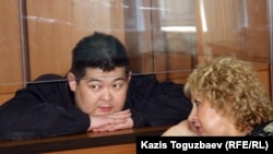 Former Kyrgyz State Committee for National Security agent Aldayar Ismankulov (behind glass) with lawyer Svetlana Murzina in court on June 6