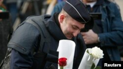 A French policeman places flowers outside the Bataclan concert hall in Paris the morning after nearly 100 people were killed there by Islamist gunmen.