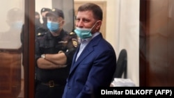 Khabarovsk Governor Sergei Furgal stands inside a defendants' cage during a court hearing in Moscow on July 10. 