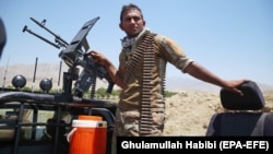 An Afghan soldier stands guard at a checkpoint after security forces cleared the area of Taliban militants in Afghanistan's Laghman Province on July 8.