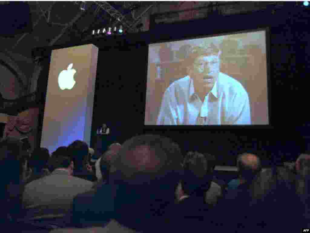 Microsoft Chairman Bill Gates appears on screen next to Apple CEO Jobs (center, on stage) to announce a partnership in August 1997 that included shareholding and Gates&#39; seat on the Apple board.