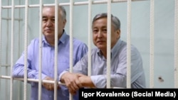 Kyrgyz oppositionists Omurbek Tekebaev (left) and Duishonkul Chotonov in court on August 11. 