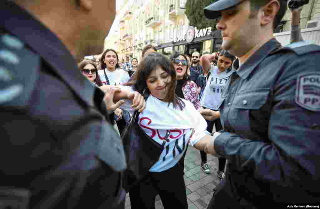 A women&rsquo;s rights protester is detained by police in Baku on October 20.