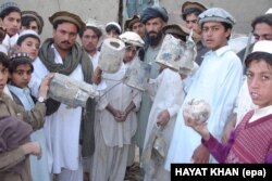 Hayatullah Khan's photo of villagers with missile shrapnel from a U.S. drone strike in North Waziristan that reportedly killed senior Al-Qaeda leader Abu Hamza Rabia in December 2005.