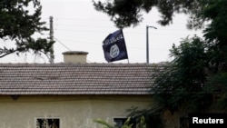 An Islamic State flag flies over the custom office of Syria's Jarablus border gate as it is pictured from the Turkish town of Karkamis. (file photo)