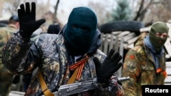 An armed man in front of the police headquarters in Slovyansk