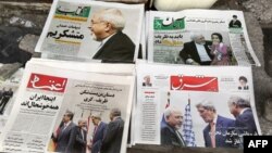 Iranian newspapers headlining the deal made in November between major powers and Iran over that country's disputed nuclear deal are displayed on the ground outside a kiosk in Tehran on November 25.