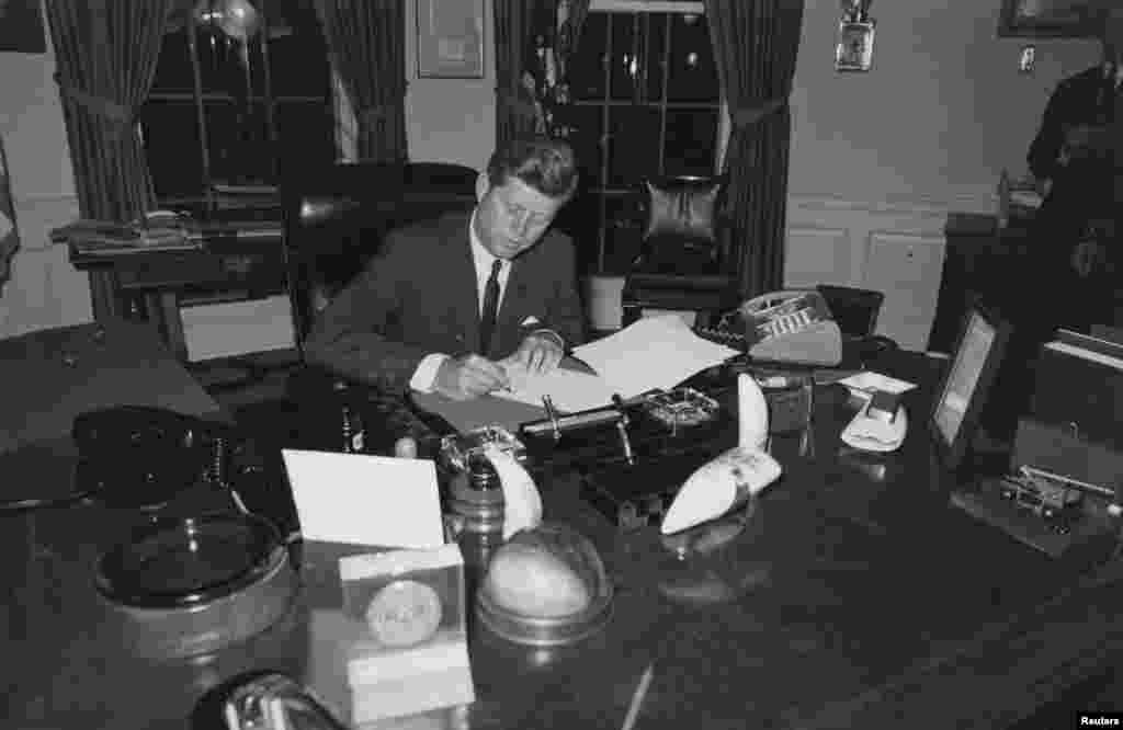 President Kennedy at the White House signing a proclamation to stop the delivery of offensive weapons to Cuba during the Cuban missile crisis in October 1962.