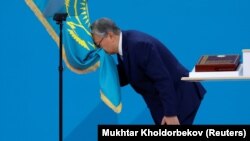 Qasym-Zhomart Toqaev kisses the state flag during his presidential inauguration ceremony in Nur-Sultan on June 12.