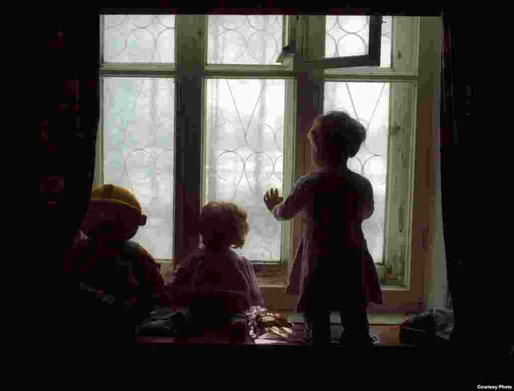 A toddler gazes out a window at a special orphanage for HIV-infected children in Ust-Izhora outside St. Petersburg, circa 2002. Children at this orphanage were typically abandoned by their parents. They received medical treatment but were virtually sealed off from outside life and were rarely allowed to leave the grounds of the facility. 