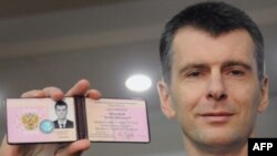 Mikhail Prokhorov shows the document from Russia's Central Election Commission certifying his candidacy for the presidency. 