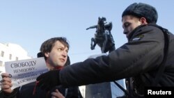 A policeman detains one of the opposition activists holding the so-called "single picket" in support of jailed opposition members in Moscow on January 5.