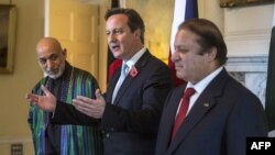 British Prime Minister David Cameron (center), Afghan President Hamid Karzai (left) and Pakistani Premier Nawaz Sharif (right) pose for pictures ahead of their trilateral meeting in Downing Street, London, on October 29.