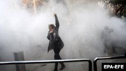 A young woman raises her fist aloft as Iranian students clash with riot police in Tehran during antigovernment protests that rocked Iran for around two weeks at the turn of the year. 