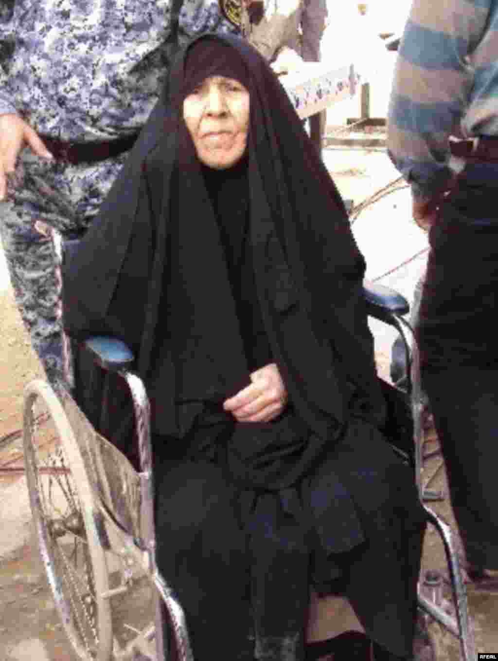 An elderly Iraqi woman is assisted by security personnel at a polling station in Baghdad. (Photo: Radio Free Iraq)