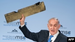 Israeli Prime Minister Benjamin Netanyahu holds up an object, which he claimed was a piece of an Iranian drone shot down in Israeli airspace, during his speech at the Munich Security Conference on February 18. 