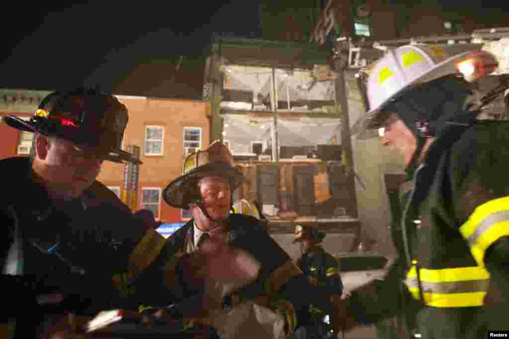 Firefighters work in front of a partially collapsed four-story apartment building in Manhattan.