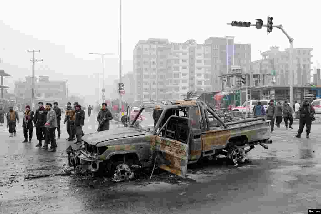 Afghan policemen inspect at the site of the explosion.