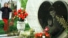 A girl walks past the grave of Admira Ismic and Bosko Brkic, a Muslim-Serb couple buried together after being killed in no-man's land in wartime Sarajevo in 1993.