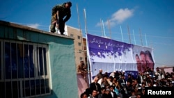 A security guard keeps watch during a rally by Afghan presidential candidate Zalmai Rasul in Mazar-e Shariff on March 27.