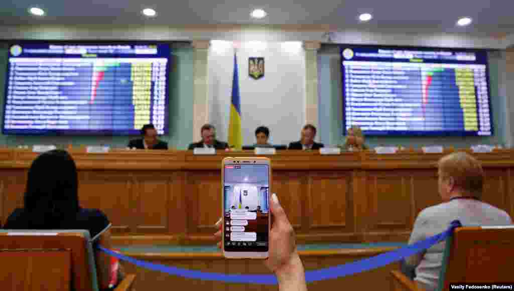 A journalist broadcasts a session of Ukraine&#39;s Central Electoral Commission live via a mobile phone in Kyiv, April 1, 2019. ( Reuters / Vasily Fedosenko)