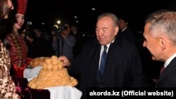 Kazakh President Nursultan Nazarbaev (center) is welcomed by Tatarstan's president, Rustam Minnikhanov, (right) in Kazan on June 14. 