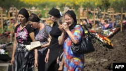 Relatives and friends mourn one of the more than 170 victims in a cemetery in the town of Krymsk in the southern Krasnodar region on July 9.