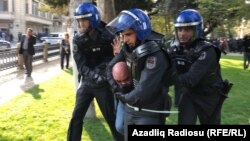 An activist is taken away by police in Baku today.