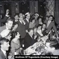 Josep "Tito" Broz smokes a pipe as party guests sing during a massive gathering in Belgrade in 1960.