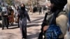 Afghan women pass a Taliban fighter on a street Kabul on February 13.