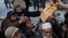 People reach out to receive bread in Kabul.