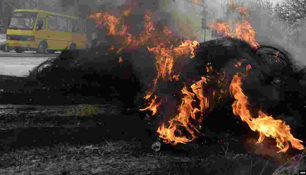 Burning tires are piled up on the motorway to block the international E40 highway in Novoyavorivsk.