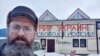 Dmitry Skurikhin stands in front of his store, which calls for peace in Ukraine and freedom in Russia.