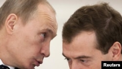 President Dmitry Medvedev (right) listens to Prime Minister Vladimir Putin during a meeting with regional governors.