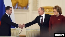 Russian President Vladimir Putin (center) greets Prime Minister Dmitry Medvedev and speaker of the Federation Council Valentina Matviyenko during a session of the State Council at the Kremlin in Moscow on December 27, when the upper house backed the bill.