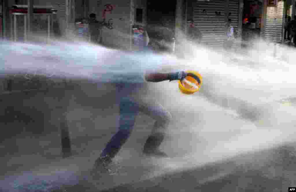 A Turkish protester runs as police used water cannon during clashes on Istiklal Avenue in Istanbul. (AFP/Bulent Kilic)