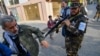 A Taliban fighter pushes a journalist covering a demonstration by women protesters outside a school in Kabul on September 30, 2021.