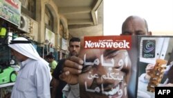 A man shows the Arabic copy of Newsweek magazine ahead of U.S. President Barack Obama trip to the Middle East.