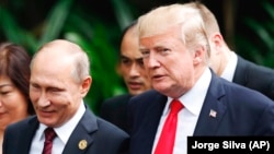 A file photo of U.S. President Donald Trump (right) and Russian President Vladimir Putin at the APEC Summit in Vietnam last year. 