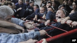 Ukrainian police try to restrain supporters of Yulia Tymoshenko outside the district court in Kyiv where her trial resumed on September 27.