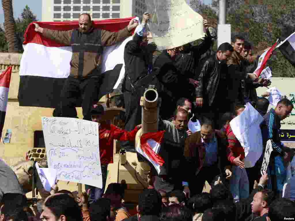 Mubarak supporters shout slogans atop an army tank near Tahrir Square.