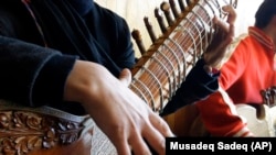 In this photo from 2013, an Afghan girl practices playing the sitar in a class at the Afghanistan National Institute of Music (ANIM) in Kabul.