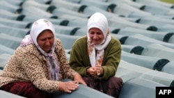 Bosnian Muslim women weep by a relative's coffin among those of other Srebrenica victims at the Potocari memorial center.