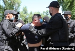 A man wearing a protective face mask is detained during an unsanctioned rally held by Kazakh opposition supporters in Almaty in June 2020.